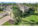 Aerial view of a home with lush landscaping, a spacious yard, and a brick driveway at 11417 Okaloosa Dr, Venice, FL 34293