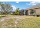 Wide backyard featuring a screened-in patio, green lawn, and mature landscaping at 11417 Okaloosa Dr, Venice, FL 34293