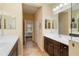 Primary bath features double sinks with a view to an open door and bedroom in the background at 11417 Okaloosa Dr, Venice, FL 34293