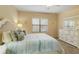 Cozy bedroom featuring bright walls, a large window, ceiling fan, nautical decor, and white furniture at 11417 Okaloosa Dr, Venice, FL 34293