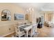 Bright dining room featuring a white table with seating for six, complemented by beach-themed decor and ample natural light at 11417 Okaloosa Dr, Venice, FL 34293