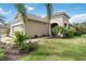 Beautiful one-story home with a tan exterior, a tile roof, and a meticulously landscaped front yard at 11417 Okaloosa Dr, Venice, FL 34293