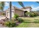 Attractive home featuring a two-car garage, a tile roof, and a beautifully landscaped front yard with mature palms at 11417 Okaloosa Dr, Venice, FL 34293