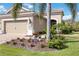 Inviting home featuring lush landscaping, a brick walkway, and mature palm trees enhancing curb appeal at 11417 Okaloosa Dr, Venice, FL 34293