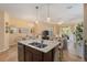 Inviting kitchen flows into living and dining areas, featuring a granite island with sink and seating at 11417 Okaloosa Dr, Venice, FL 34293