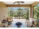 Relaxing screened-in patio with comfortable seating and views of the lush landscaping at 11417 Okaloosa Dr, Venice, FL 34293