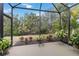 Serene screened-in patio with lush landscaping, providing a peaceful outdoor space at 11417 Okaloosa Dr, Venice, FL 34293