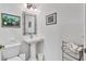 Powder room with pedestal sink, custom mirror, and a decorative wall art at 13313 Gasparilla Rd # C501 & Slip 11, Placida, FL 33946