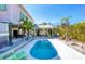 Private backyard boasts a refreshing pool, covered seating area, lush palms, and tropical landscaping at 14 Palm Dr, Placida, FL 33946