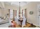 Dining room with elegant chandelier, seating for six, and bright windows with patterned curtains at 14 Palm Dr, Placida, FL 33946