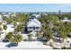Charming elevated beach house nestled among lush palm trees with a white picket fence at 14 Palm Dr, Placida, FL 33946