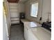 Functional laundry room with washer, dryer, shelving, and a utility sink for added convenience at 1417 Terry Ave, Punta Gorda, FL 33980