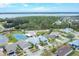 Aerial view of a beautiful neighborhood with a pool, tennis court, and lake in the background at 14281 Palm Ter, Port Charlotte, FL 33953
