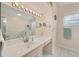 Bright bathroom features a large mirror, vanity, and separate bathtub at 14281 Palm Ter, Port Charlotte, FL 33953
