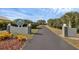 Community sign entrance, showcasing a tree-lined driveway and manicured landscaping at 14281 Palm Ter, Port Charlotte, FL 33953