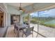 Relaxing enclosed lanai features a dining set and views of the tennis court and pond at 14281 Palm Ter, Port Charlotte, FL 33953