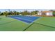 Well-maintained tennis court featuring bright blue surface with green trim in a fenced in area at 14281 Palm Ter, Port Charlotte, FL 33953