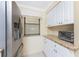 Charming kitchen with white cabinets, granite countertops, and stainless steel refrigerator at 1651 Beach Rd # 311, Englewood, FL 34223