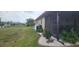 Backyard featuring a screened patio, well maintained lawn, and decorative landscaping at 171 Caddy Rd, Rotonda West, FL 33947