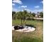 Scenic backyard featuring landscaping with small palm trees, lush green grass, and water views at 171 Caddy Rd, Rotonda West, FL 33947