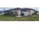 Side view of a home's exterior with a lush lawn and decorative white rock landscaping at 171 Caddy Rd, Rotonda West, FL 33947