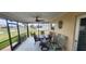 Screened-in patio area with a ceiling fan and outdoor seating overlooking the canal at 171 Caddy Rd, Rotonda West, FL 33947