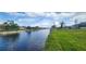 Scenic view of a wide canal waterway featuring lush green banks and single Gathering homes in the background at 171 Caddy Rd, Rotonda West, FL 33947