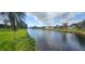 A view of a waterway with lush green banks and homes in the background on a sunny day at 171 Caddy Rd, Rotonda West, FL 33947