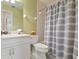 Clean bathroom featuring a shower with a gray-striped curtain and white fixtures at 202 Silver Lake Dr # 203, Venice, FL 34292
