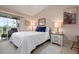 Bright bedroom with a sliding glass door to the balcony, neutral carpet, and a comfortable bed at 202 Silver Lake Dr # 203, Venice, FL 34292