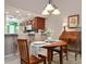Quaint dining area with a decorative light fixture and a view of the kitchen and breakfast bar at 202 Silver Lake Dr # 203, Venice, FL 34292
