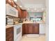 Modern kitchen featuring wooden cabinets and updated appliances, open to the living area at 202 Silver Lake Dr # 203, Venice, FL 34292