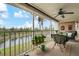 Inviting screened patio with seating, lush potted plants, and scenic views of the pond and trees at 202 Silver Lake Dr # 203, Venice, FL 34292