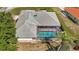Aerial view of home featuring a screened pool, lush landscaping, and a well-maintained roof at 217 Rockwood Way, Englewood, FL 34223