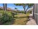 View of the backyard featuring mature trees and a partial view of the neighboring pool at 217 Rockwood Way, Englewood, FL 34223