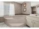 Large garden tub in bathroom features neutral tile and a privacy window at 217 Rockwood Way, Englewood, FL 34223