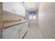 Well-organized laundry room with ample storage, counter space, and a utility sink at 217 Rockwood Way, Englewood, FL 34223