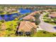 Stunning aerial view of a home with a tile roof, lush landscaping, and a community lake at 2625 Wax Myrtle, Port Charlotte, FL 33953