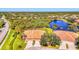 Scenic aerial view showcasing tile roofs, well-manicured lawns, and tranquil lake views for a serene community at 2625 Wax Myrtle, Port Charlotte, FL 33953