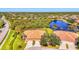Scenic aerial view showcasing tile roofs, well-manicured lawns, and tranquil lake views for a serene community at 2625 Wax Myrtle, Port Charlotte, FL 33953