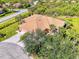Elevated street view showcasing house with tile roof, large driveway and lush landscaping at 2625 Wax Myrtle, Port Charlotte, FL 33953