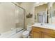 Bathroom featuring a glass-enclosed shower, neutral tile, a single sink vanity, and decorative wall accents at 2625 Wax Myrtle, Port Charlotte, FL 33953
