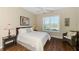 Cozy bedroom with wood floors, a ceiling fan, and a window with shutter blinds overlooking the landscape at 2625 Wax Myrtle, Port Charlotte, FL 33953