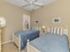Bedroom with two twin beds, blue bedding, and white wooden frames under a ceiling fan at 2625 Wax Myrtle, Port Charlotte, FL 33953