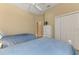 Bedroom features two twin beds, white dresser, closet with white doors, and a ceiling fan at 2625 Wax Myrtle, Port Charlotte, FL 33953
