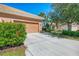 Home exterior with a two-car garage, well-maintained driveway, and a neatly landscaped front yard with flowering shrubs at 2625 Wax Myrtle, Port Charlotte, FL 33953