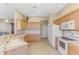 Corner kitchen with light wood cabinets and views to the living area at 2625 Wax Myrtle, Port Charlotte, FL 33953