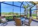 Screened lanai offering outdoor seating, a ceiling fan, and a serene view of the lake at 2625 Wax Myrtle, Port Charlotte, FL 33953