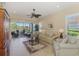 Comfortable living room with plush seating, tile flooring, a ceiling fan, and scenic views through large windows at 2625 Wax Myrtle, Port Charlotte, FL 33953