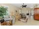 Comfortable living room with plush sofas, a ceiling fan, tile floors, and a view of the home's entryway at 2625 Wax Myrtle, Port Charlotte, FL 33953